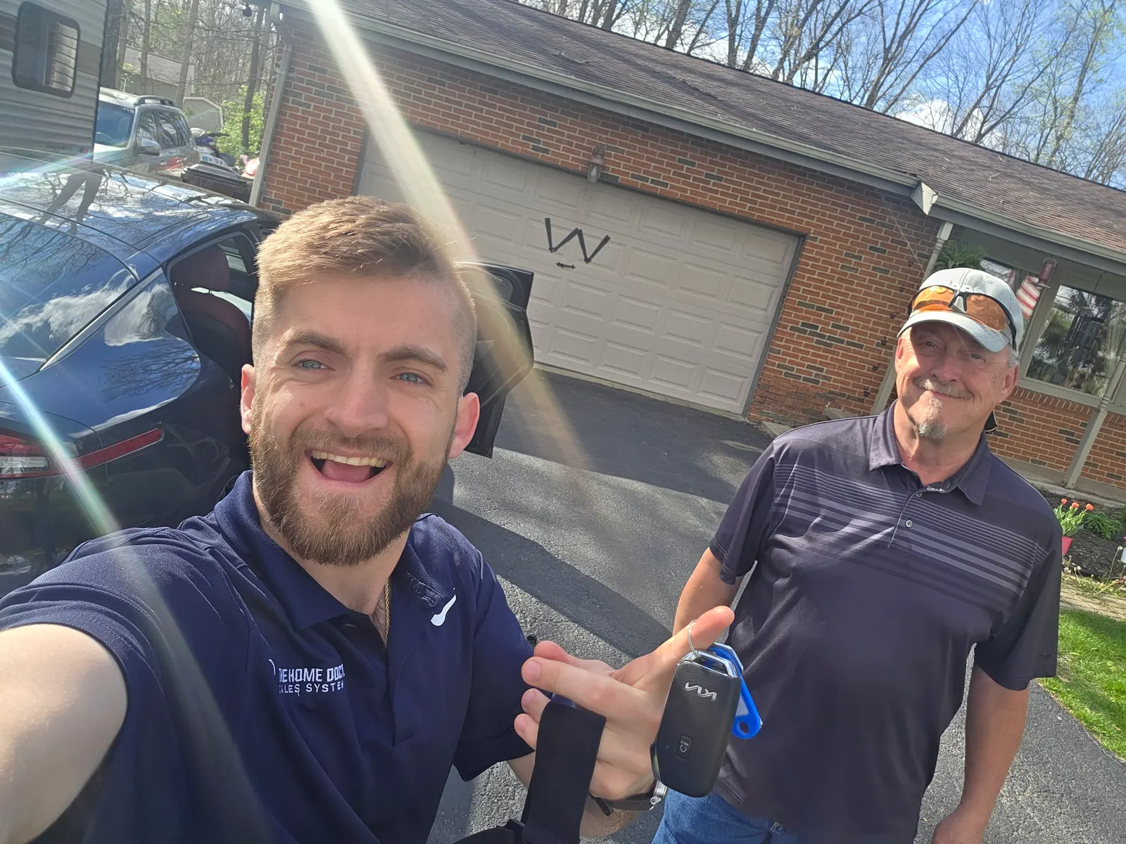 Noah Williams with a roofing contractor outside a home