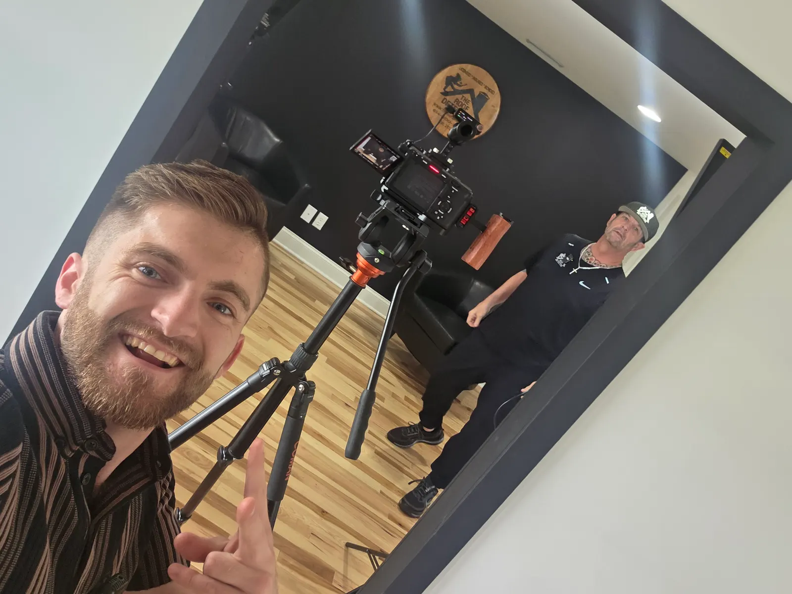 Camera on a tripod filming a roofing contractor in his office