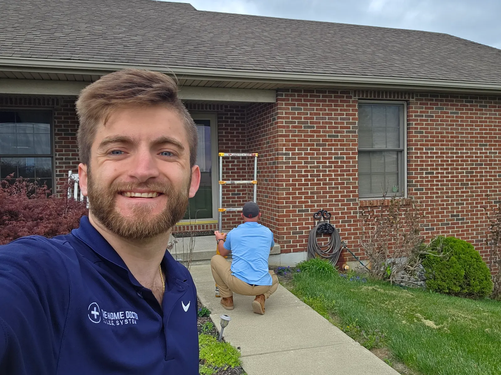 Noah Williams of Roofory at a brick home while a roofer inspects the house